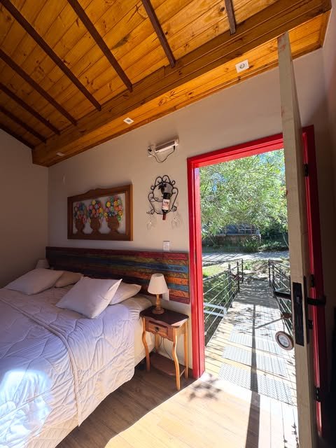 Quarto com porta aberta para a varanda e a natureza